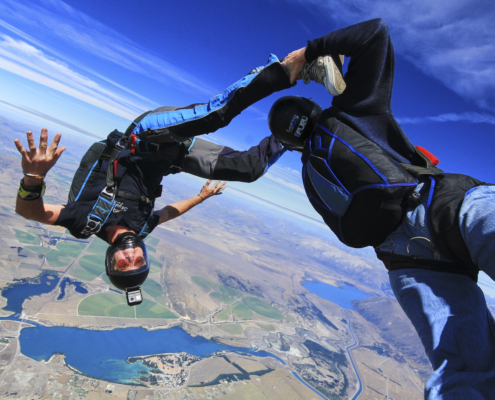 Two men doing a sport skydiving stunt.