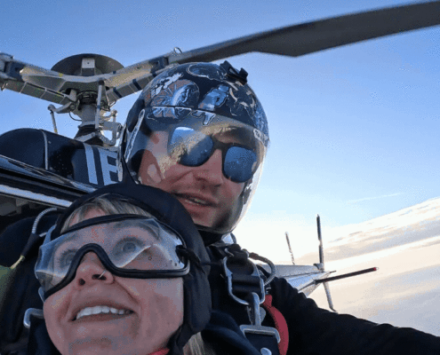 Two people jump out of helicopter in air at Mount Cook